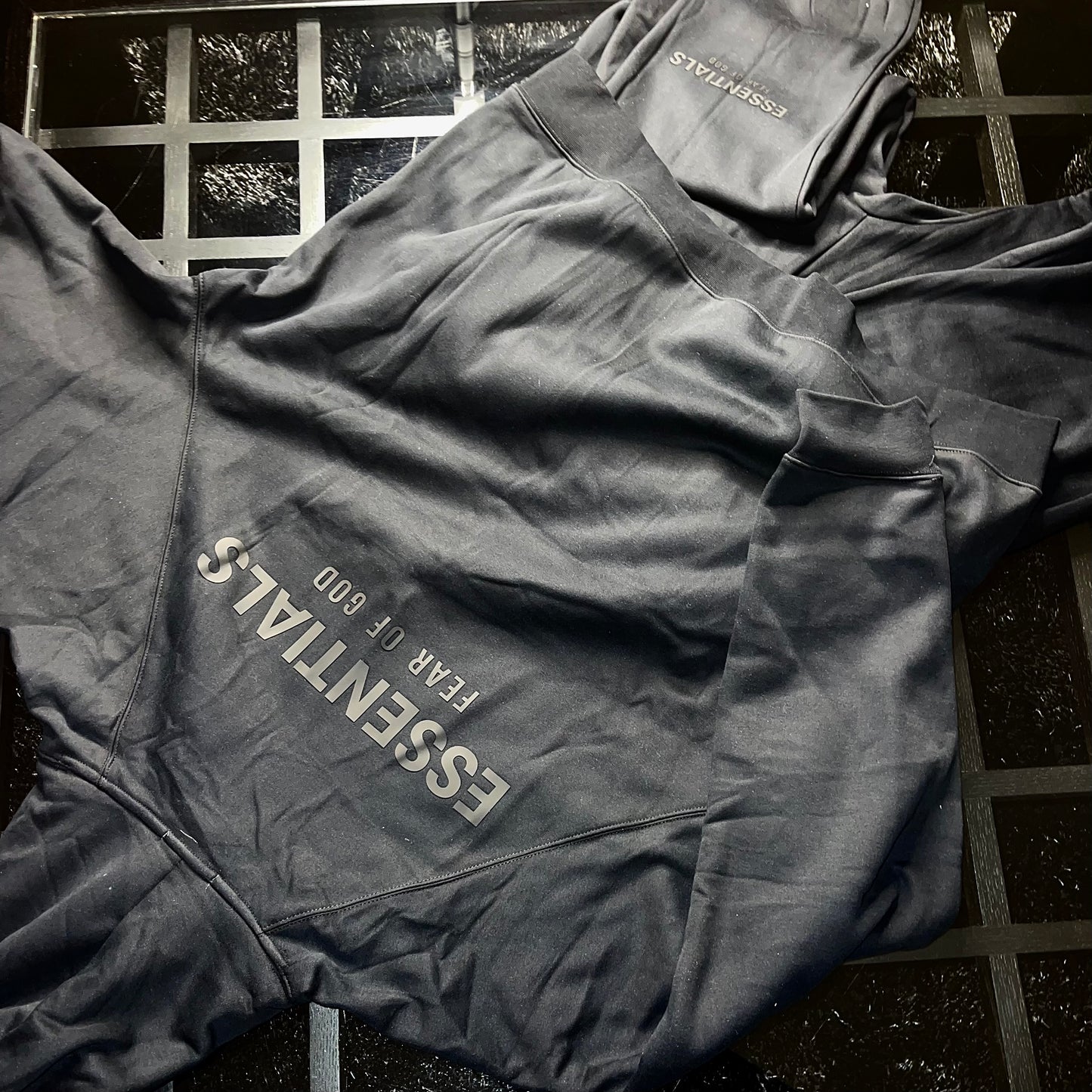 Rear view of Essentials Fear of God Core Collection Black hoodie and pants showing fit and silhouette