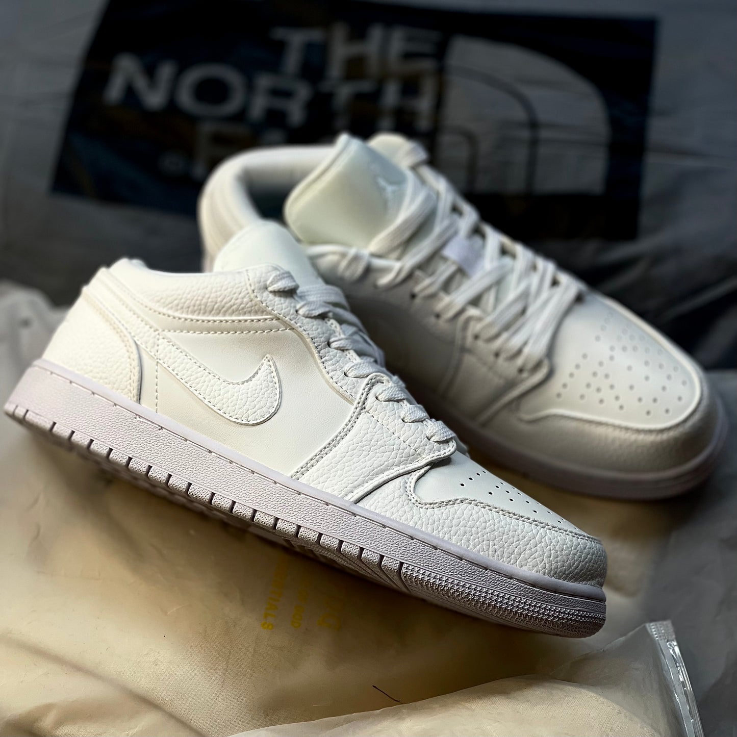 Air Jordan 1 Low Triple White featuring tonal Nike Swoosh and Air Jordan Wings logo on heel