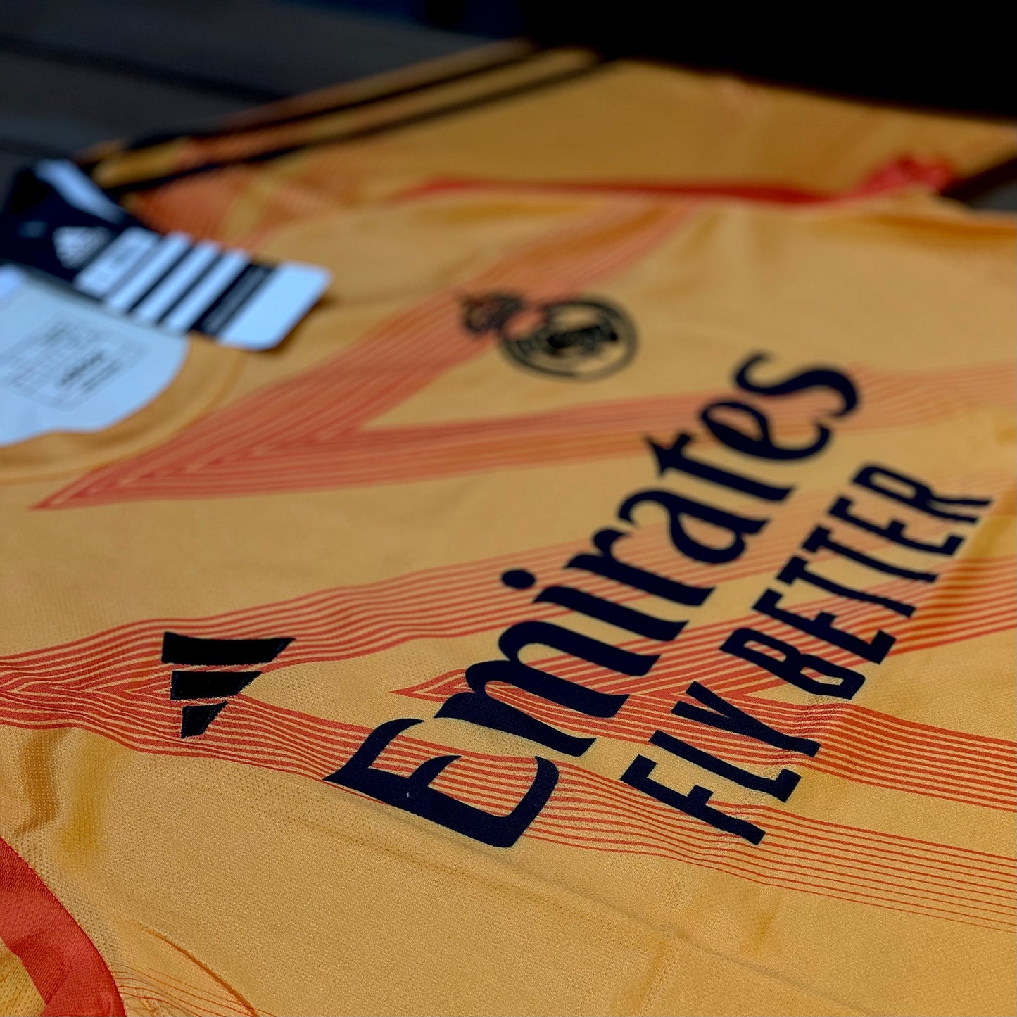 Close-up of a Real madrid sports jersey with Emirates branding and text.