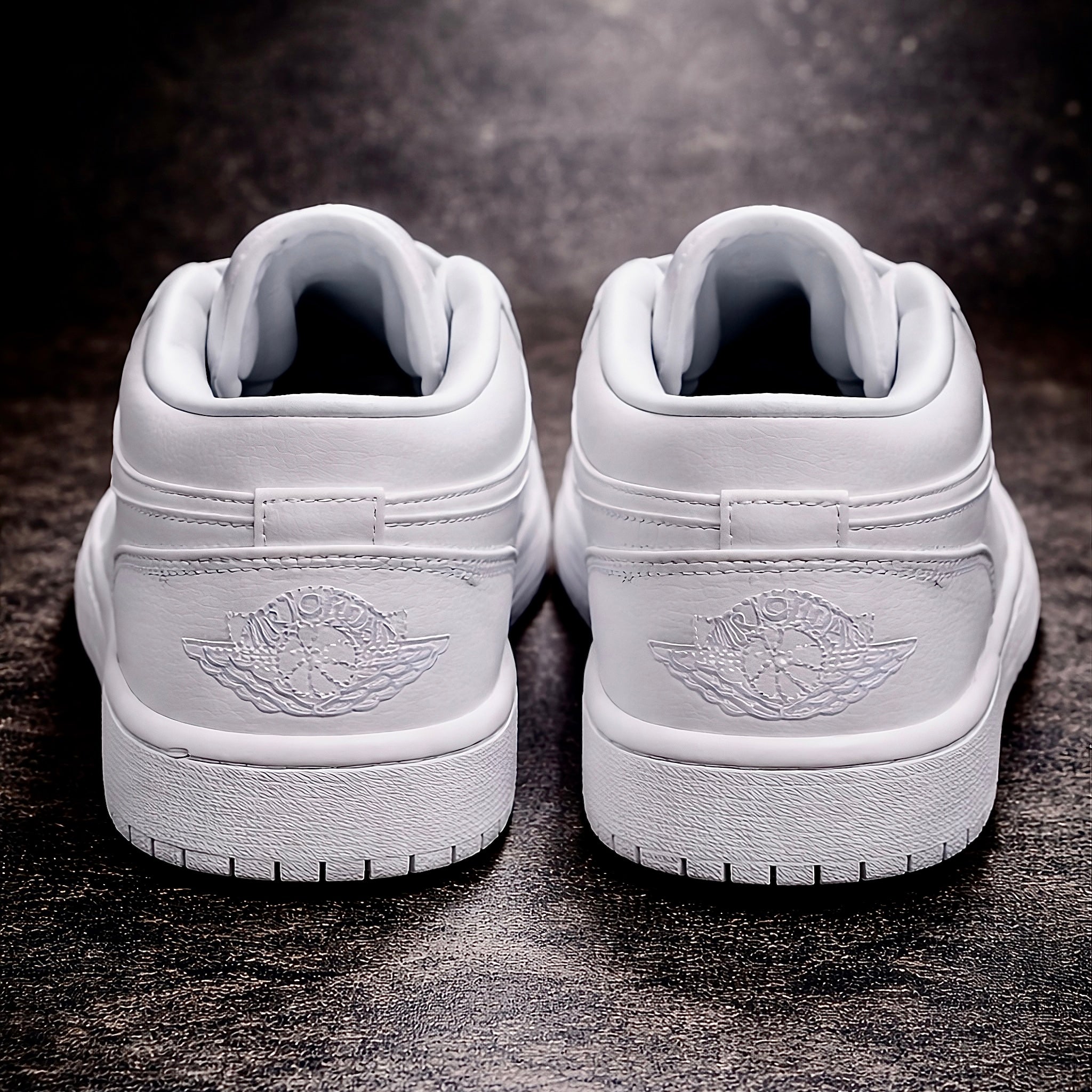 Air Jordan 1 Low Triple white Rear view on polished dark concrete floor