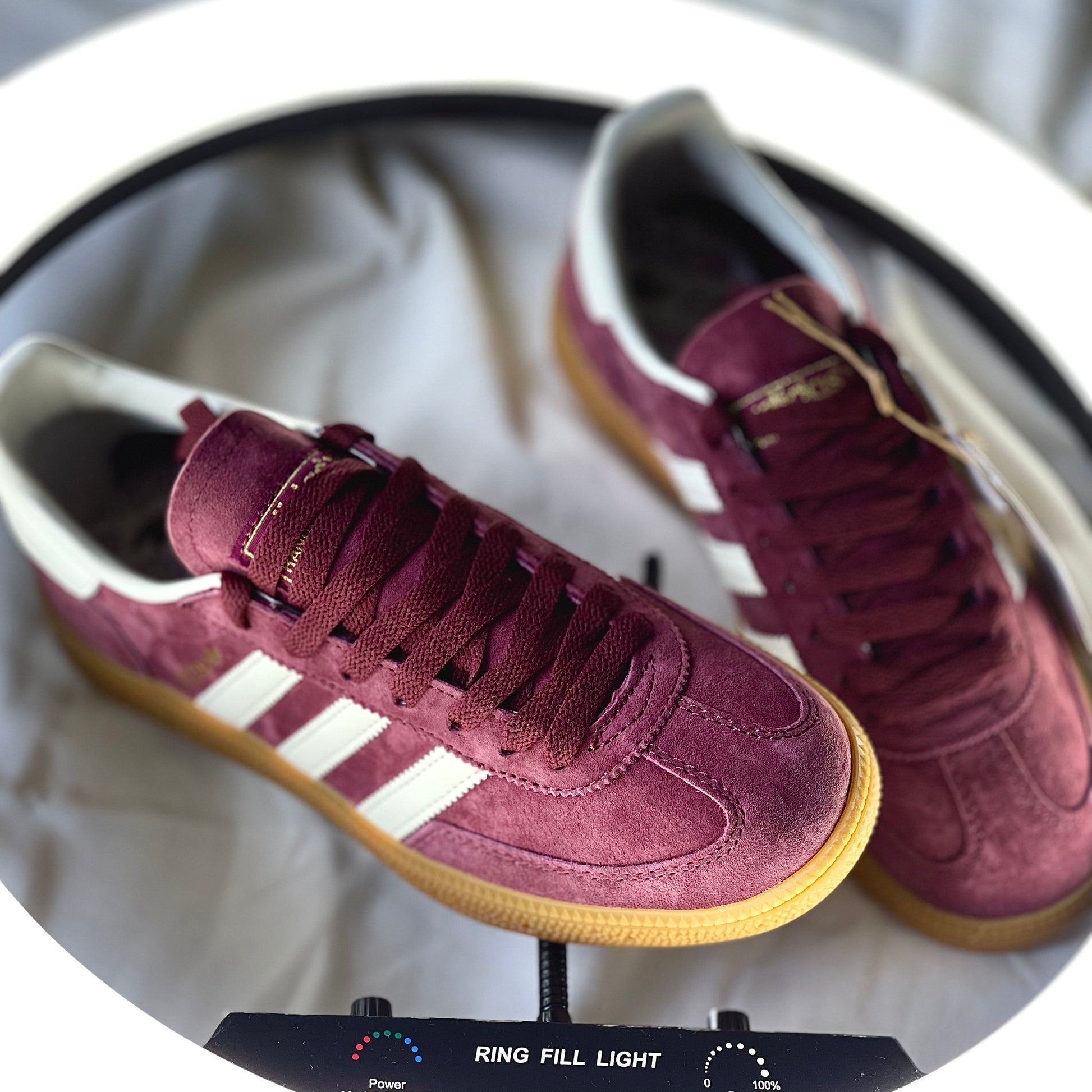 Close-up of Adidas Handball Spezial Burgundy suede upper with cream three-stripe detail
