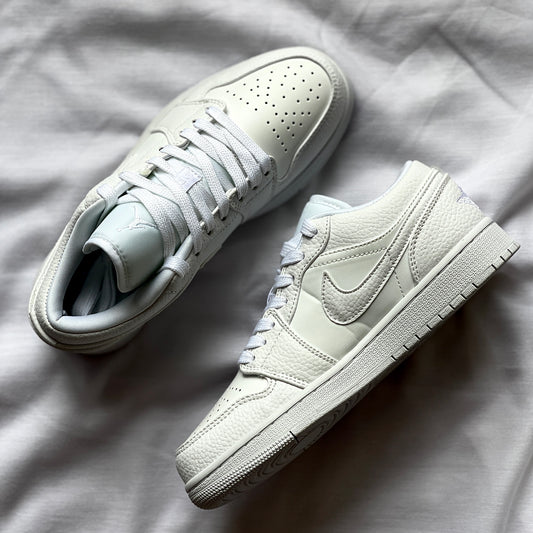 Close-up of Air Jordan 1 Low Triple White showing premium leather texture, stitching, and Air Jordan logo.