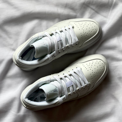Top view of Air Jordan 1 Low Triple White highlighting laces, tongue, and smooth leather construction.