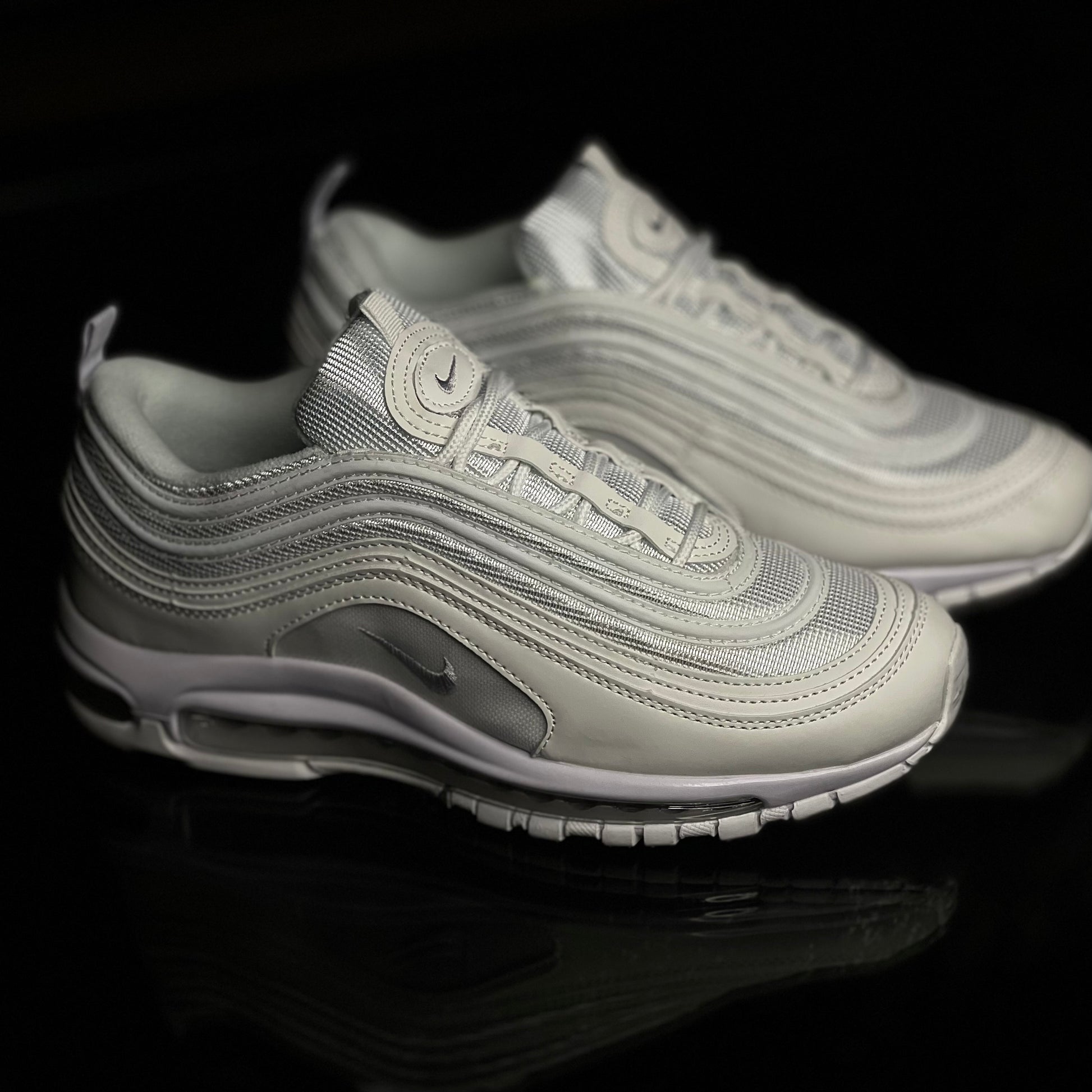 Nike Air Max 97 Triple White side view — all-white sneaker with signature wavy upper lines and full-length visible Air unit