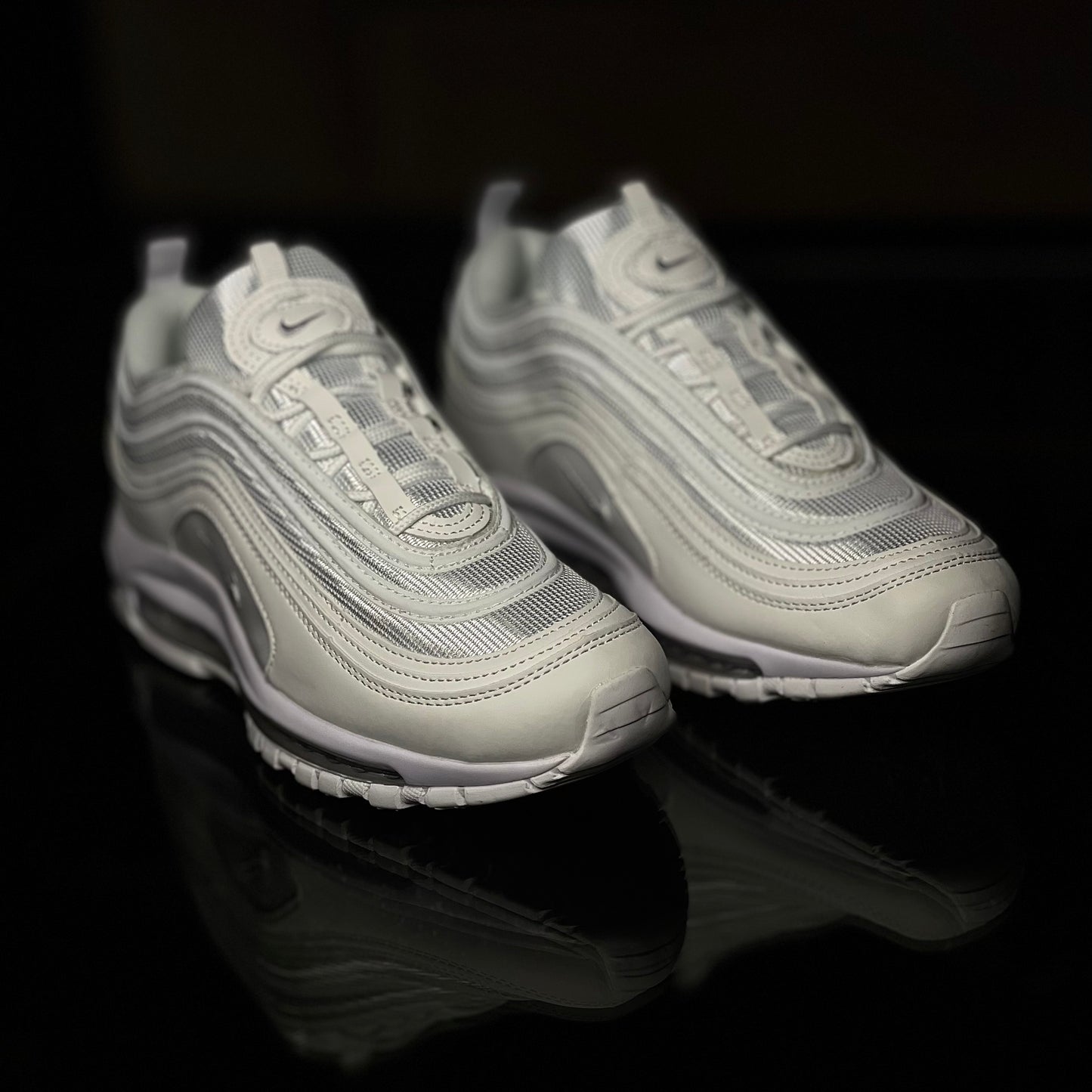 Angled view of Air Max 97 Triple White — iconic wavy sneaker design in all-white highlighting retro-modern style