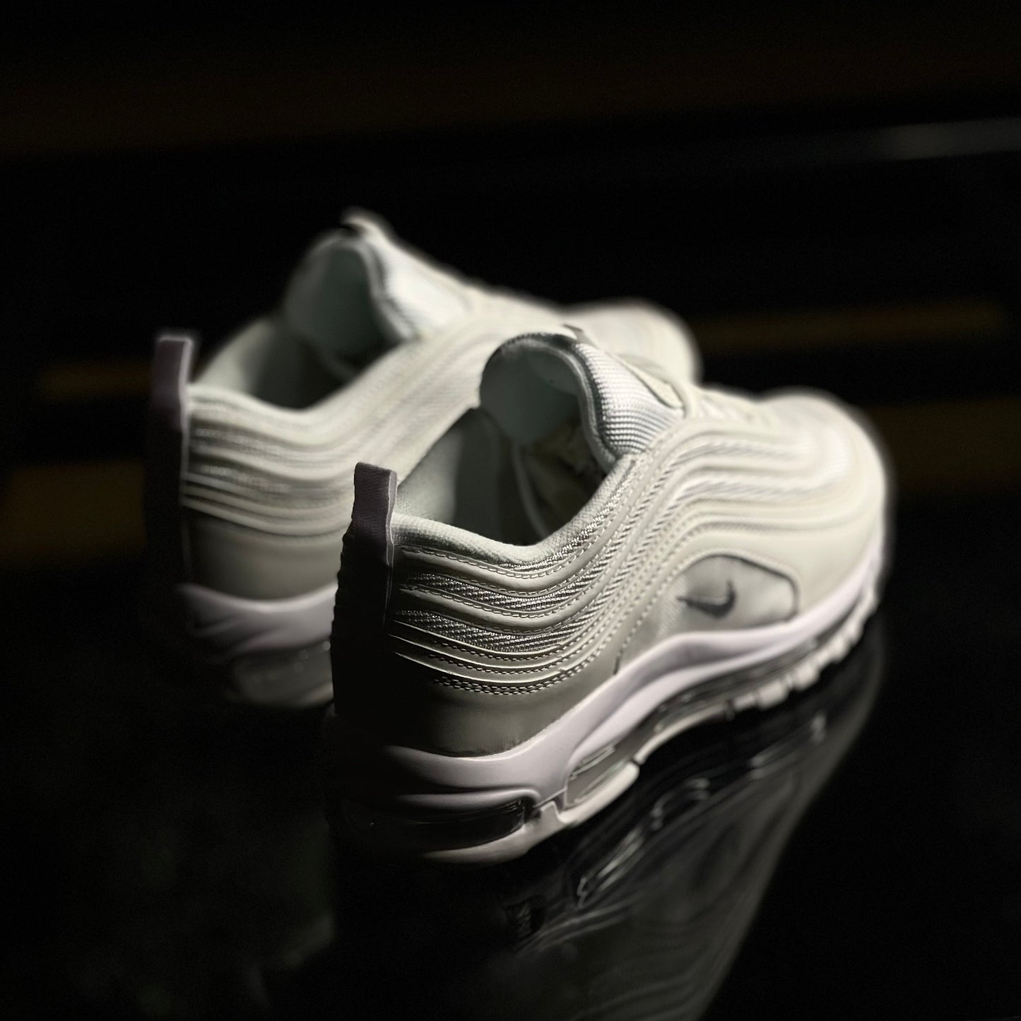 Back view of Nike Air Max 97 Triple White — heel tab with subtle branding and layered panel design