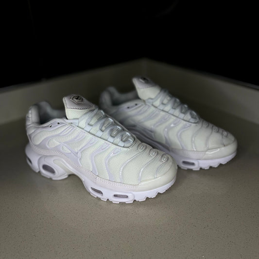 Nike Air Max Plus Triple White side view — all-white sneaker with signature wavy TPU overlays and visible Air cushioning
