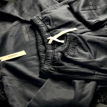 Detailed view of Essentials Fear of God logo on chest and leg of Core Collection tracksuit