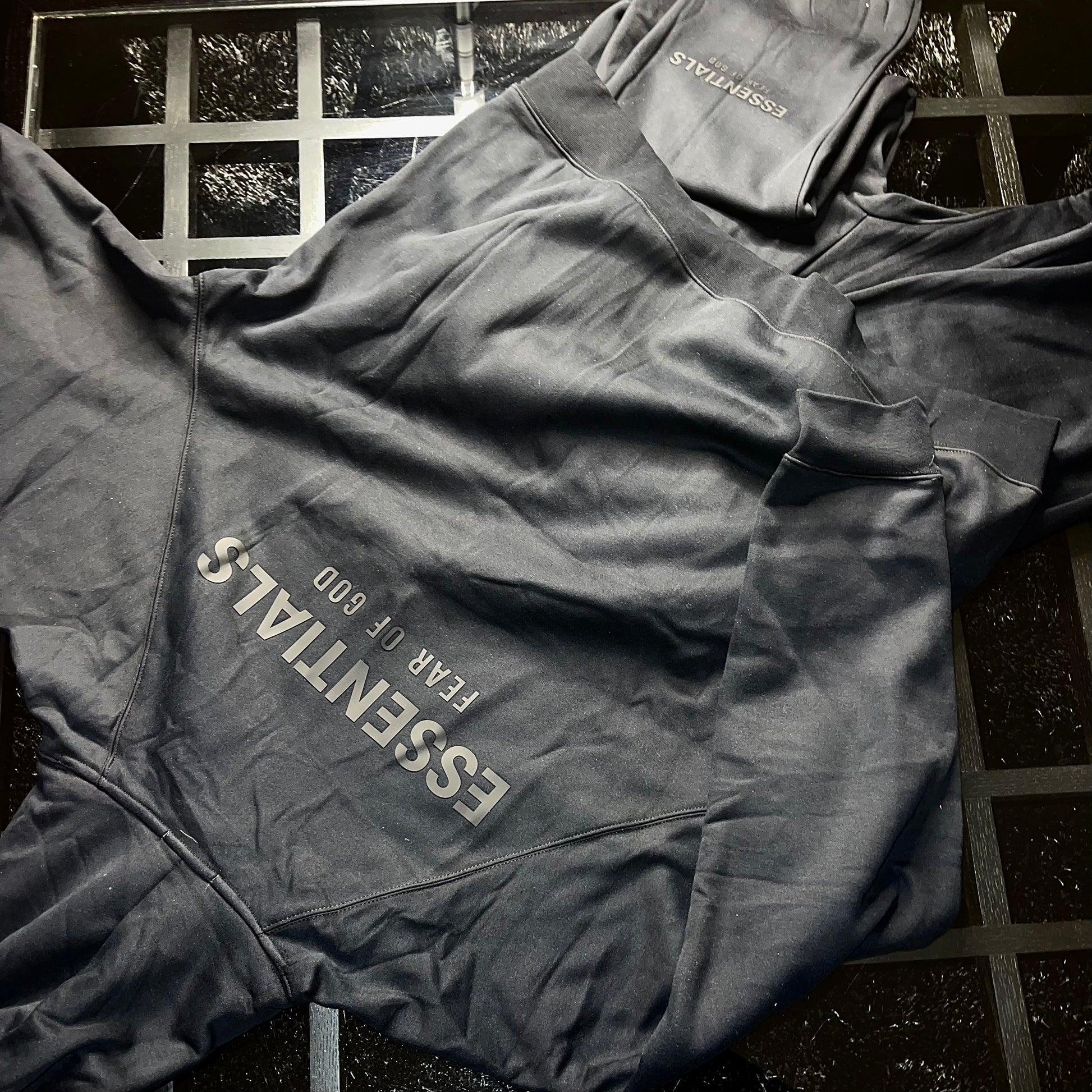 Rear view of Essentials Fear of God Core Collection Black hoodie and pants showing fit and silhouette