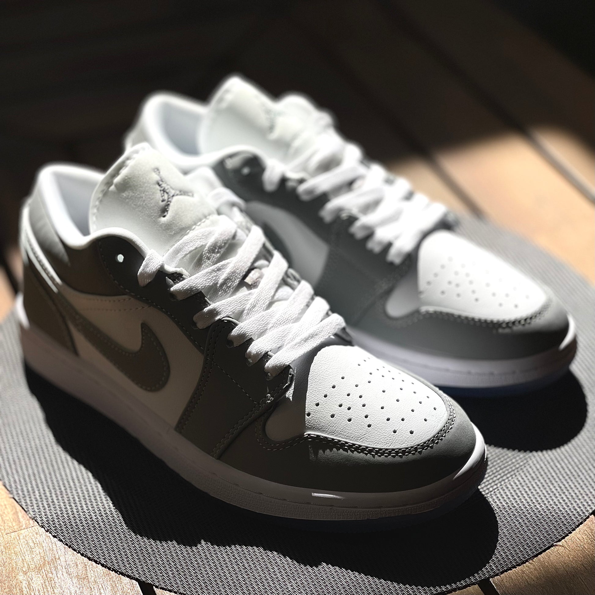 Close-up of Air Jordan 1 Low Wolf Grey leather upper with white base and grey overlays