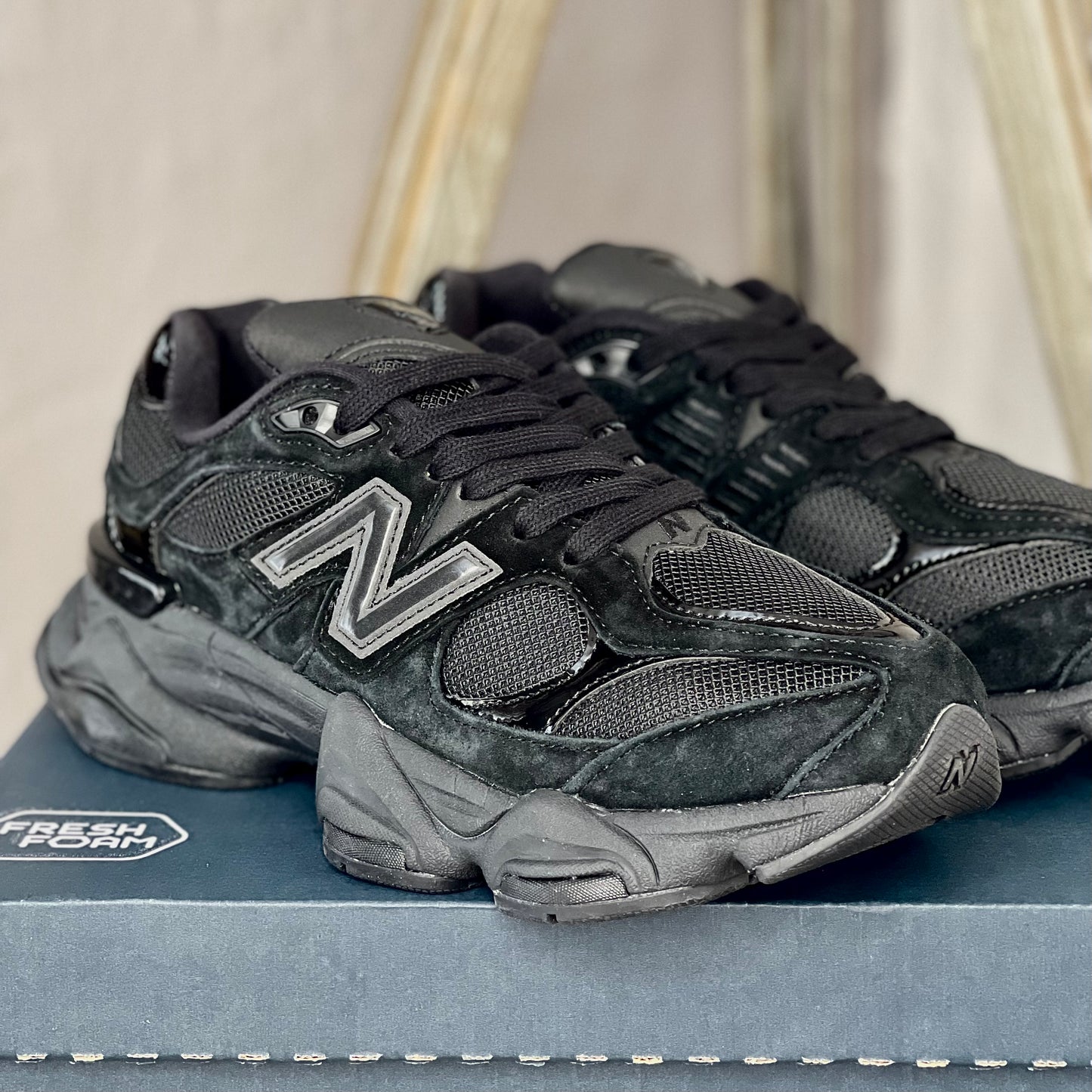 Close-up of New Balance 9060 Black Cat — detailed black leather and mesh textures with refined stitching and branding