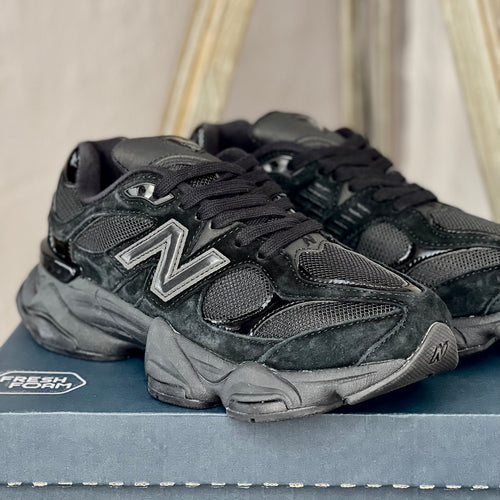 Close-up of New Balance 9060 Black Cat — detailed black leather and mesh textures with refined stitching and branding