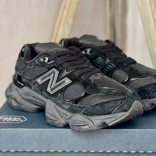 Close-up of New Balance 9060 Black Cat — detailed black leather and mesh textures with refined stitching and branding