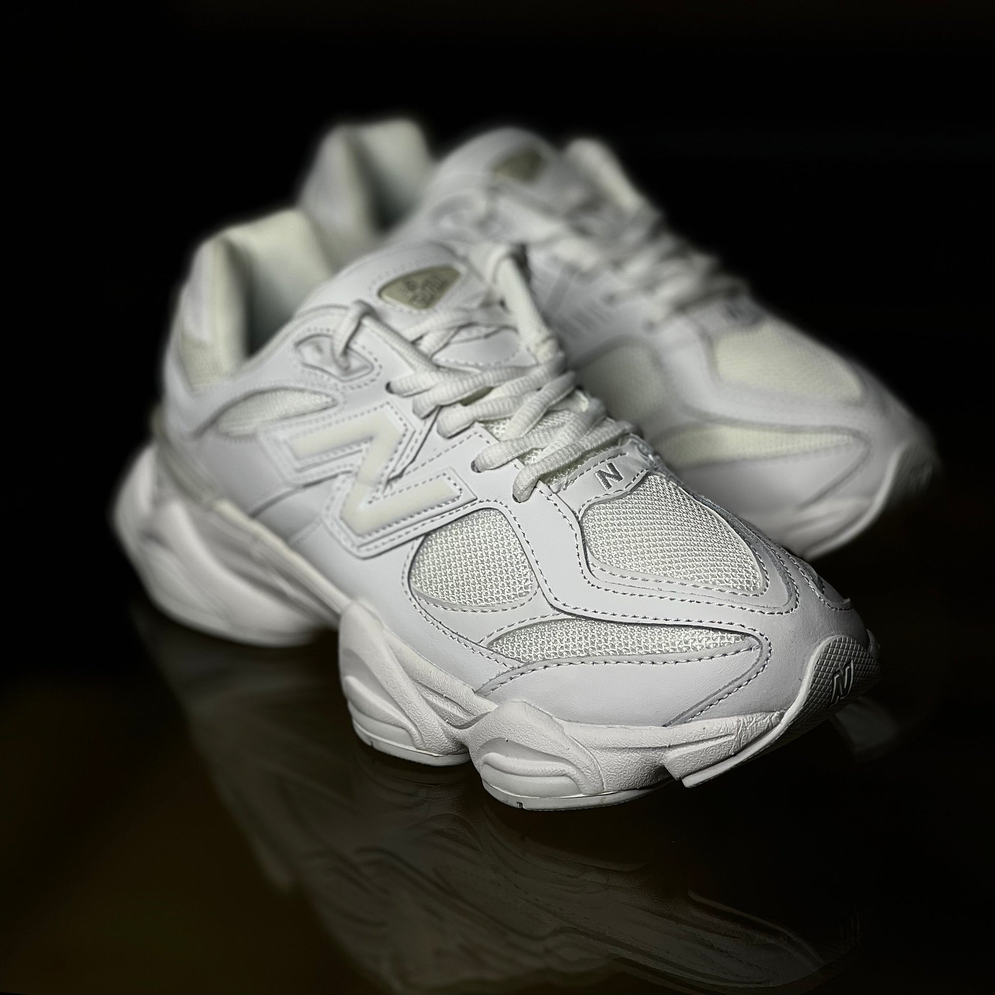Angled view of New Balance 9060 Triple White — sleek all-white sneaker highlighting modern-retro layered design