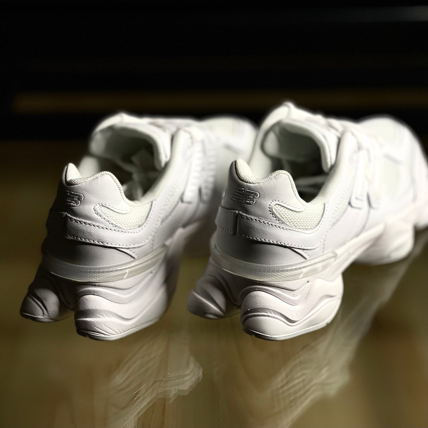 Close-up of New Balance 9060 Triple White — detailed white leather and mesh textures with refined stitching and branding