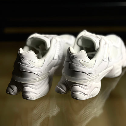 Close-up of New Balance 9060 Triple White — detailed white leather and mesh textures with refined stitching and branding