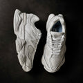 Pair of New Balance 9060 Triple White sneakers angled together