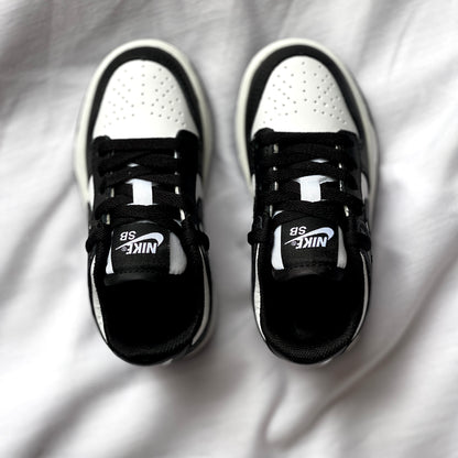 Top view of Nike Dunk Low Panda kids’ sneaker highlighting laces, tongue, and two-tone leather upper.