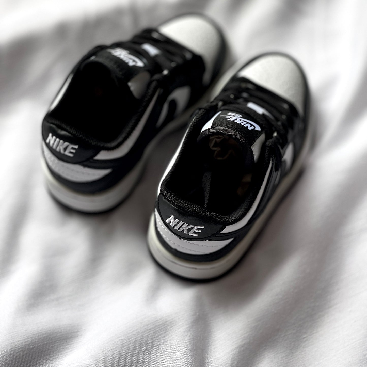 Rear view of Nike Dunk Low Panda kids’ sneaker highlighting heel tab, stitching, and two-tone colorway.