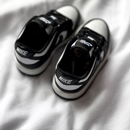 Rear view of Nike Dunk Low Panda kids’ sneaker highlighting heel tab, stitching, and two-tone colorway.
