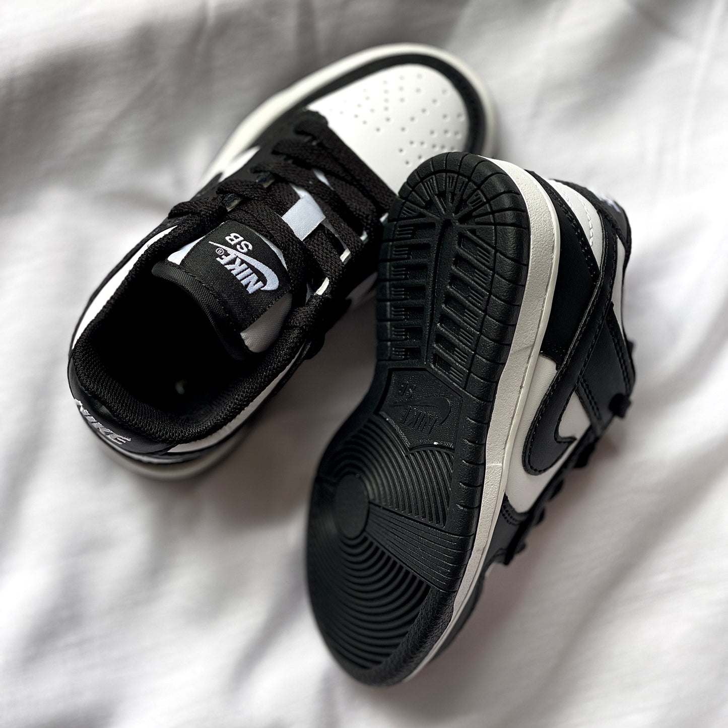 Outsole of Nike Dunk Low Panda kids’ sneaker featuring black rubber traction pattern.