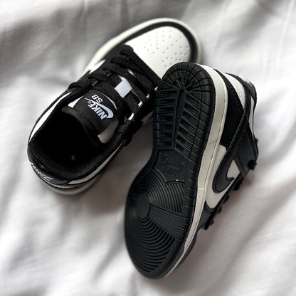 Outsole of Nike Dunk Low Panda kids’ sneaker featuring black rubber traction pattern.