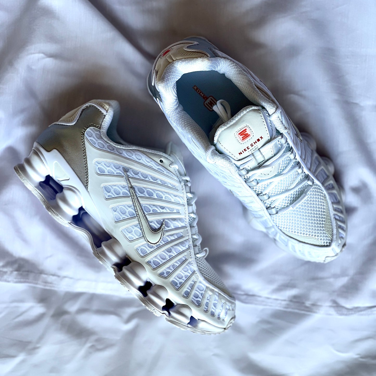 Pair of Nike Shox TL Metallic Silver sneakers angled together
