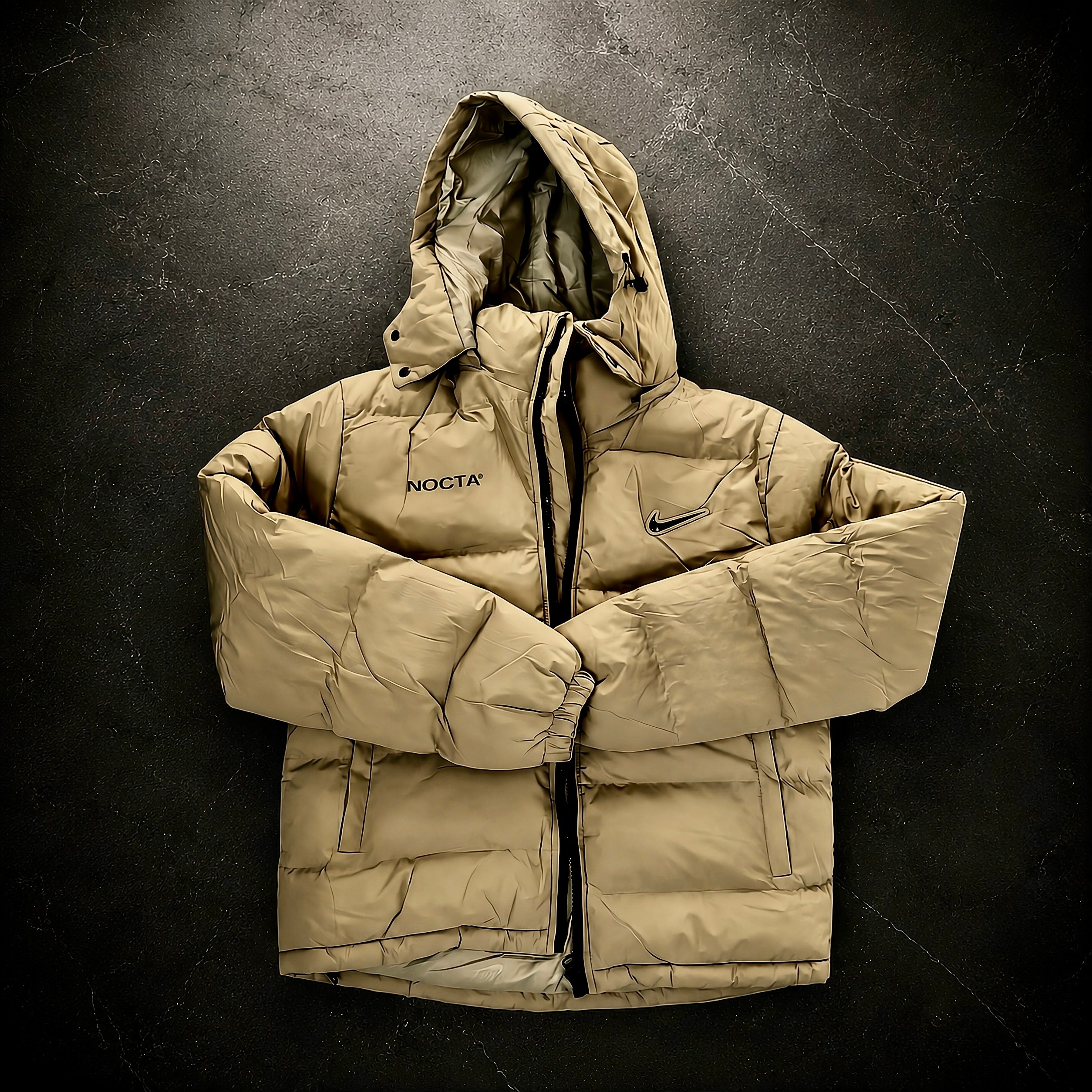 Nike x Drake NOCTA Storm-FIT Skulpeak Puffer Jacket Bone front view featuring insulated quilted construction, full-zip closure, adjustable hood and NOCTA branding.