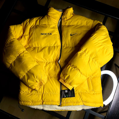 Nike NOCTA Reversible Puffer Jacket University Gold front view on clean background