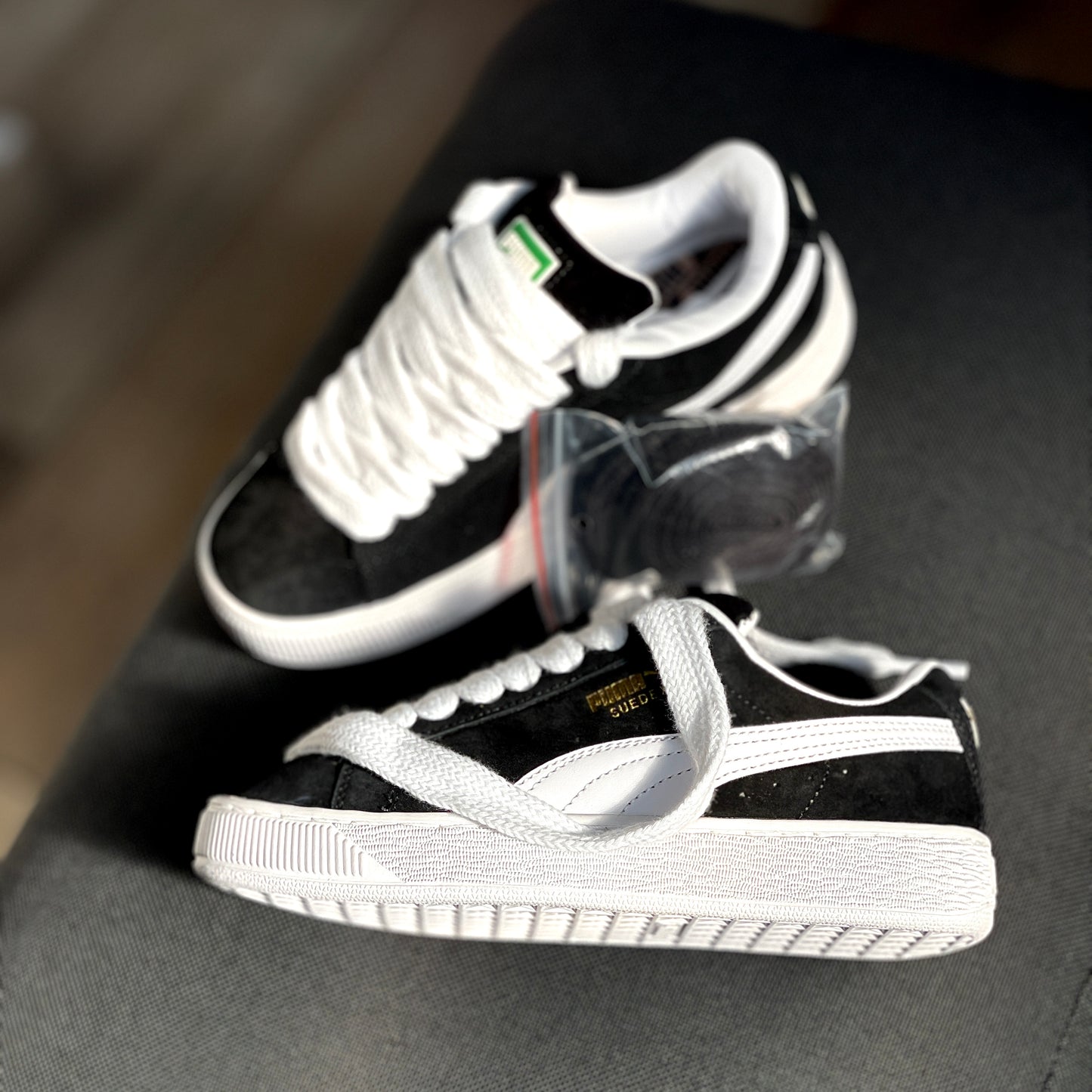 Pair of Puma Suede XL Black White sneakers angled together