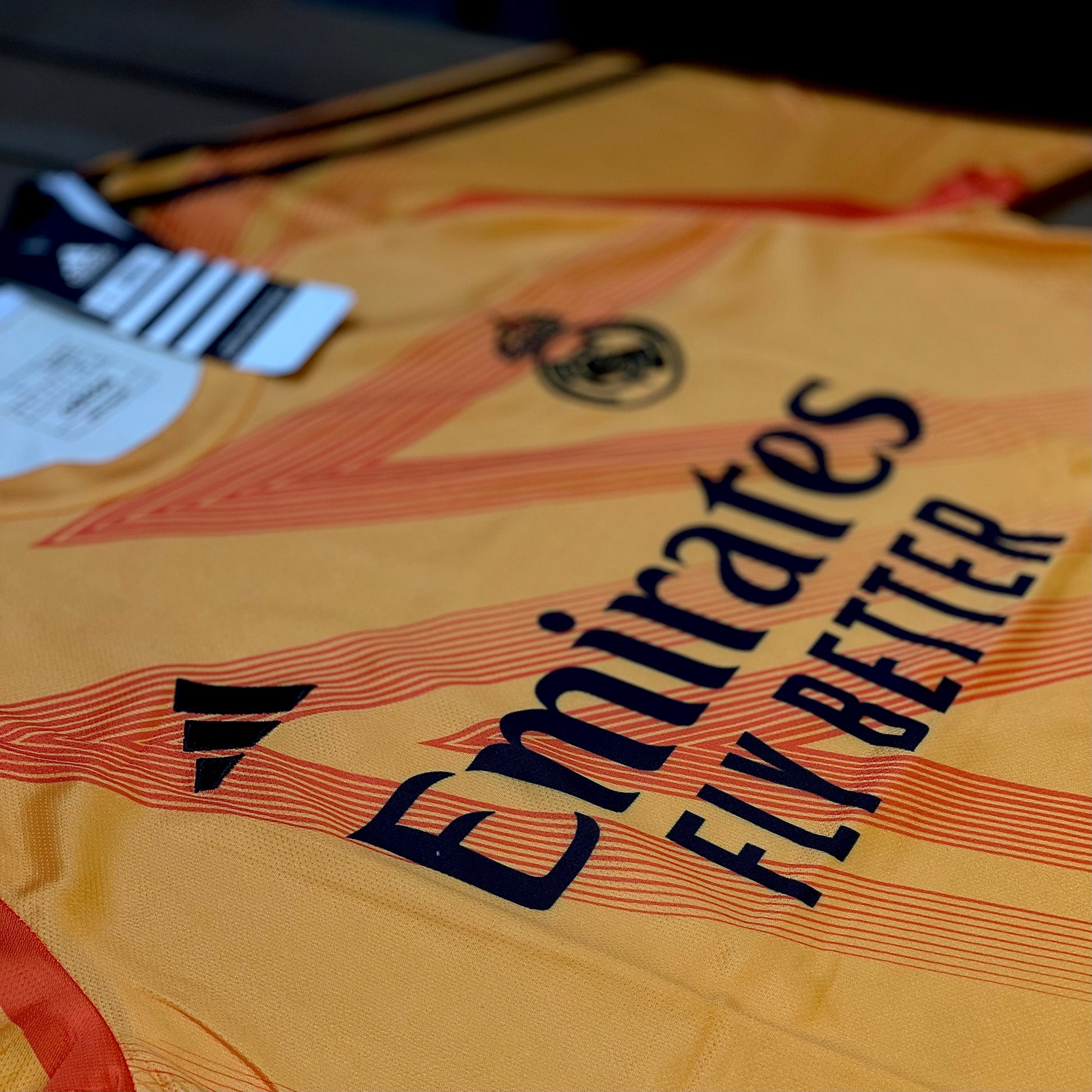 Close-up of a Real madrid sports jersey with Emirates branding and text.