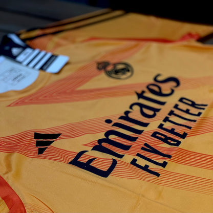 Close-up of a Real madrid sports jersey with Emirates branding and text.